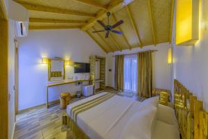 a bedroom with a large bed with a wooden ceiling at Ameera Maldives in Dhiffushi