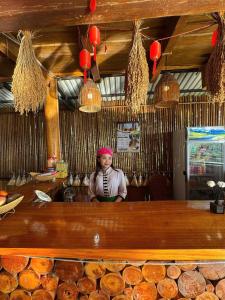 a woman standing behind a counter in a restaurant at Mai Hill Homestay in Ải Hạ