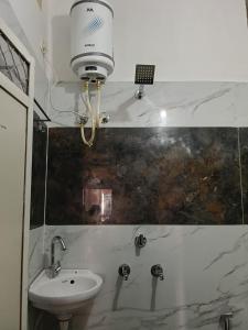 a bathroom with a sink and a light on the wall at KeshavShree home stay in Ujjain