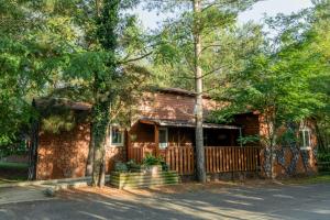 una casa de madera con una valla y árboles en Domaine de Dienné - Villages Vacances, en Dienné
