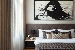 1 dormitorio con 1 cama con una pintura en la pared en Brill Budapest Apartments 2, en Budapest