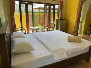 a large bed with white sheets and pillows on it at Aroma Pai Spa Hotel in Ban Tha Pai