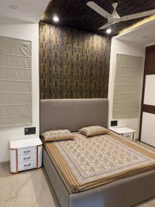 ein großes Bett in einem Zimmer mit einer Wand in der Unterkunft Madhav villa in Jaipur