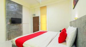 a bedroom with a bed with red pillows and a tv at OYO 412 7 Days Hotel in Chiang Mai