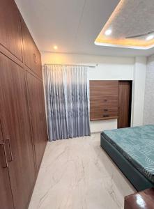 ein Schlafzimmer mit einem Bett und einem Holzschrank in der Unterkunft Madhav villa in Jaipur + 10 Fotos