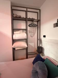 a room with a bed and a shelf with towels at Gollum-Goretti House in Mairena del Aljarafe