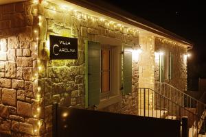 un panneau sur le côté d'un bâtiment avec des lumières dans l'établissement Villa Carolina, à Izola