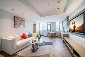 a living room with a white couch and a tv at Citadines Luyang Hefei in Hefei