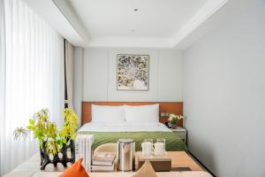 a hotel room with a bed and a desk with a table sidx sidx at Citadines Luyang Hefei in Hefei