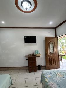 Hospedaje Nicolas في سان خوان لاجونا: غرفة نوم بها سرير وتلفزيون على الحائط +8 صور