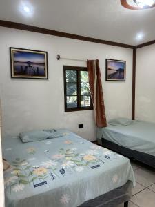 Hospedaje Nicolas في سان خوان لاجونا: غرفة نوم بسريرين ونوافذ