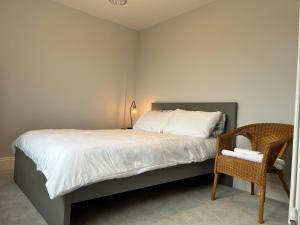 Lynwood House, Bratton في Bratton: غرفة نوم بسرير مع مصباح وكرسي