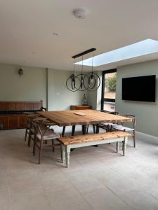 a dining room with a large wooden table and a flat screen tv at Lynwood, 5 bed, 4 bath, private large drive in Bratton