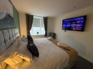 a bedroom with a bed with a television on the wall at Cleveleys Town Centre in Blackpool