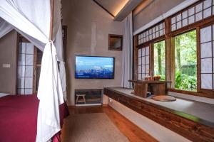 ein Zimmer mit Fernseher, Bett und Fenstern in der Unterkunft Relais & Châteaux Su Shien Valley Hotel in Dujiangyan