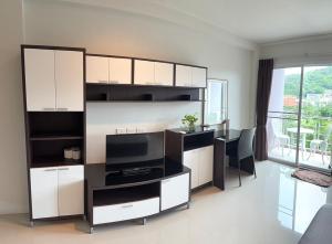 een woonkamer met witte kasten en een televisie bij Aonang Mountain View A1 in Ao Nang Beach