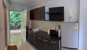 een keuken met een koelkast en een magnetron bij Aonang Mountain View A1 in Ao Nang Beach
