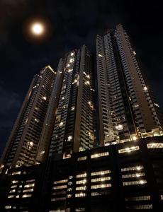 um prédio alto à noite com a lua no céu em Trizen,City & Port View Luxury Apartment in Colombo em Colombo