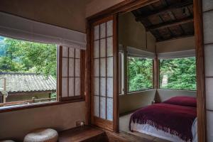 ein Schlafzimmer mit großen Fenstern und einem Bett darin in der Unterkunft Relais & Châteaux Su Shien Valley Hotel in Dujiangyan + 140 Fotos