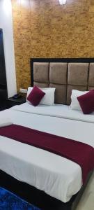 a bedroom with a large bed with red and white pillows at Glory prime suits in New Delhi