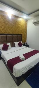 a bedroom with a large bed with red pillows at Glory prime suits in New Delhi