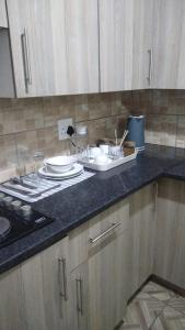 Royal Gidlas Guesthouse في Saulspoort: طاولة مطبخ عليها صحون وصحون