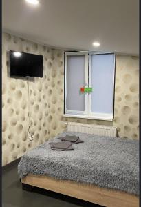 a bedroom with a bed and a flat screen tv at Family in Mukacheve