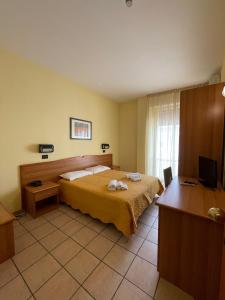 Dépendance La Perla Preziosa في غْروتّامّاري: غرفة نوم بها سرير ومكتب وتلفزيون