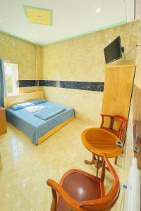 Khách Sạn Khánh Bình - Bình Dương في Tân Uyên: غرفة نوم بها سرير وطاولة وكرسي +41 صورة