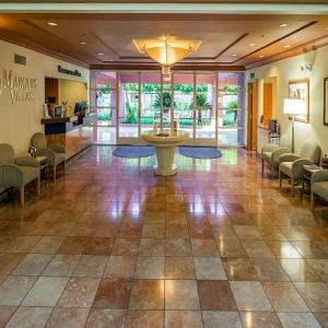 Marquis Villas Resort في بالم سبرينغز: لوبي مع غرفة انتظار مع طاولة وكراسي