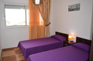 a bedroom with two purple beds and a window at Vista Cunit es una gran casa con piscina, barbacoa in Cubelles +38 photos