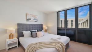 een slaapkamer met een groot bed en een groot raam bij Marina Belle in Shellharbour +18 foto's