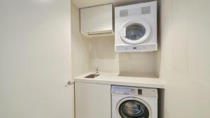 een wasruimte met een wasmachine en een wasmachine bij Marina Belle in Shellharbour
