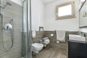 een badkamer met een toilet, een wastafel en een douche bij Appartamento Lucia in Capoliveri +17 foto's