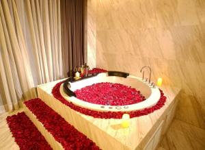 baño con bañera llena de flores rojas en Ayathorn Bangkok, en Bangkok
