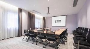 Jinjiang Inn Wuhan Hanjiang Road Metro Station Jiangtan Pedestrian Street في ووهان: غرفة مؤتمرات بها طاولة طويلة وكراسي