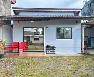 a house with red chairs on a porch at Los Glomos RestHub in Los Baños
