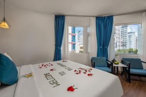 a hotel room with a bed with flowers on it at ELC Luxury Hotel Danang - An Thuong Walking Street in Da Nang