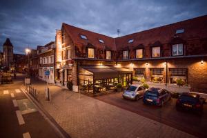 un edificio con dos coches estacionados en un estacionamiento en The Originals Boutique, Hôtel Bulles by Forgeron, Lille Sud (Qualys-Hotel), en Seclin