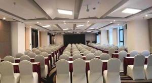 a large room with white chairs and a screen at Holiday Villa Hotel & Residence Shanghai Jiading in Xuhang