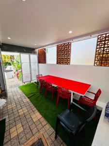 una mesa roja y sillas en una habitación en Miracle Beach Residency, en Varkala