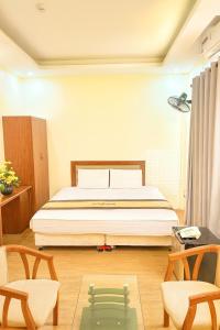 a bedroom with a bed and two chairs at Hương Sen Hotel Bac Giang in Bắc Giang +28 photos