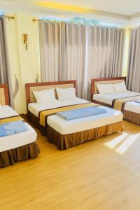 a bedroom with three beds in a room at Hương Sen Hotel Bac Giang in Bắc Giang