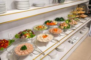 a buffet line with many plates of food on at ELC Luxury Hotel Danang - An Thuong Walking Street in Da Nang