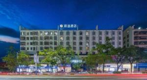 Jingtu hotel zhanjiang dingsheng plaza store في زانجيانغ: مبنى كبير مع لافتة فوقه