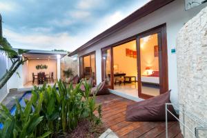 a house with a deck with a view of the backyard at Little Coco Gili Trawangan Hotel in Gili Trawangan