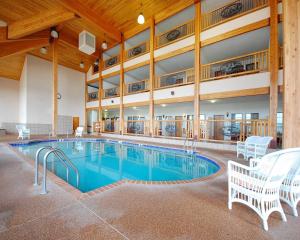 a large pool in a building with chairs and tables at Norfolk Lodge & Suites, an Ascend Collection Hotel in Norfolk