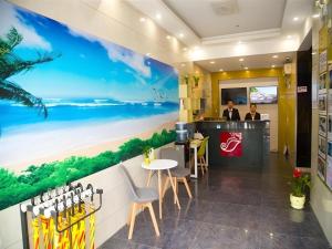 a restaurant with a beach mural on the wall at Shell Hotel Shanghai Baoshan Meilanhu Luosheng Road in Luodian