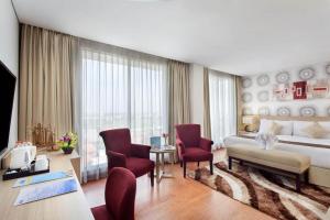a large hotel room with a bed and chairs at Days Hotel & Suites by Wyndham Jakarta Airport in Tangerang +42 photos