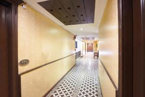Un pasillo con suelo de baldosas y un corredor. en FabHotel NFC Royale, en Nueva Delhi